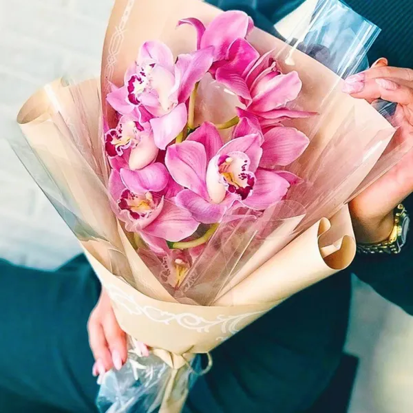 Букет из 9 розовых орхидей на ветке в оформлении
