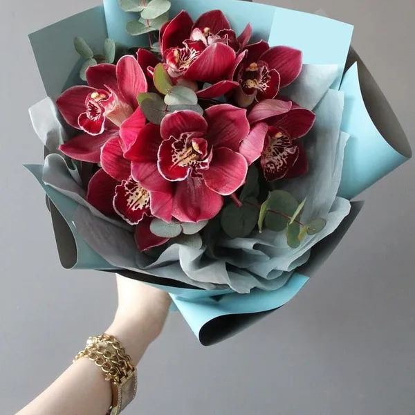 Букет из 7 малиновых орхидей в оформлении